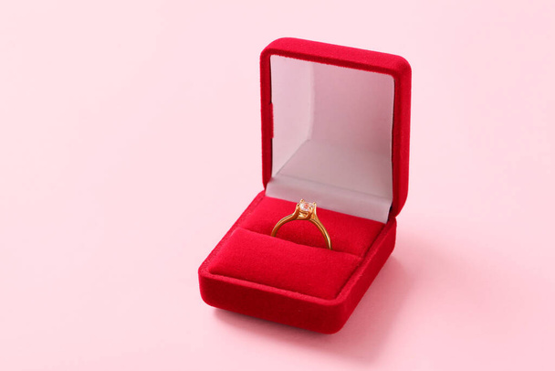 Caja con anillo de compromiso sobre fondo rosa - Foto, imagen