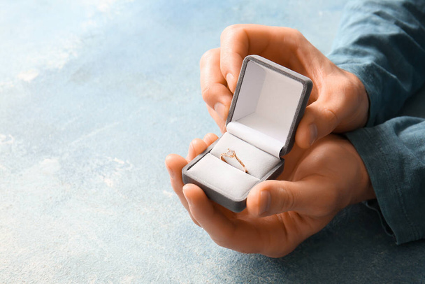 Muž drží box s zásnubním prstenem na modrém pozadí, detailní záběr - Fotografie, Obrázek
