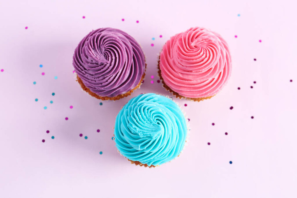 Tasty colorful cupcakes on purple background - Fotoğraf, Görsel