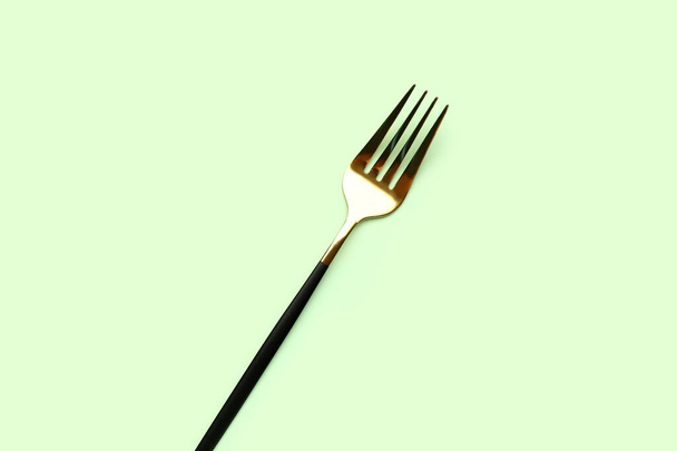 Stainless steel fork on green background - Foto, immagini