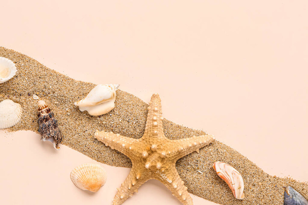 Zand met schelpen en zeesterren op lichtroze achtergrond - Foto, afbeelding