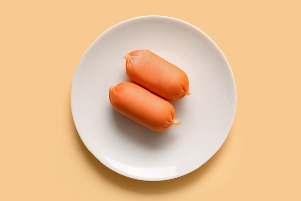 Plate of tasty boiled sausages on beige background - Fotografie, Obrázek