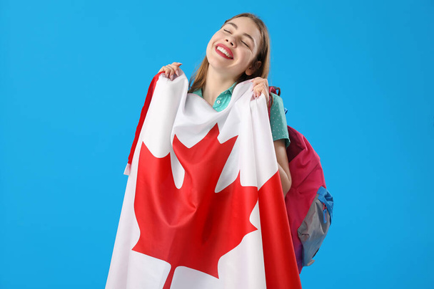 Jeune femme avec drapeau du Canada sur fond bleu - Photo, image