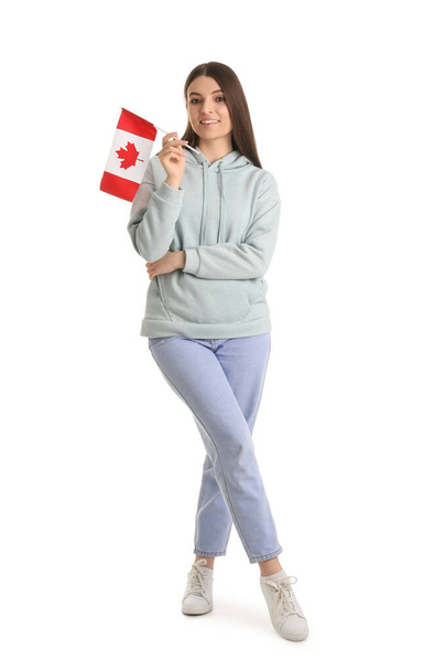 Νεαρή γυναίκα με σημαία Καναδά σε λευκό φόντο - Φωτογραφία, εικόνα