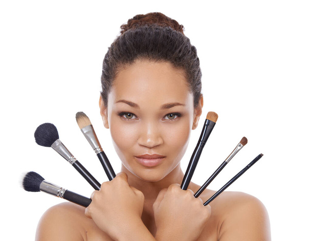 From big to small. Beauty portrait of a young woman holding up make-up brushes - Foto, Bild