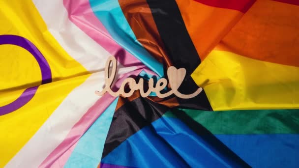 Zoomaa puinen sana rakkaus sydämen romantiikkaa Rainbow LGBTQIA lippu valmistettu silkki materiaalia. Ystävänpäivä onnittelukortti. Symboli LGBTQ ylpeys kuukausi. Tasavertaiset oikeudet. Rauha ja vapaus. Tuki - Materiaali, video