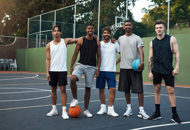 Het is niet hoe groot je bent, het is hoe groot je speelt. Portret van een groep sportieve jonge mannen die rondhangen op een basketbalveld - Foto, afbeelding