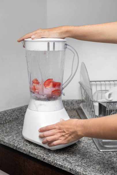 white blender design, blending fruits for a juice, modern home appliance, technology and drink preparation - Photo, Image