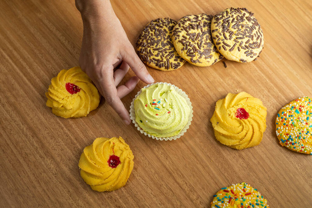 Konditorei, Bestellung köstlicher Kekse mit farbigen Dragees, Desserts im Atelier, Süßspeisen mit detaillierten Texturen - Foto, Bild