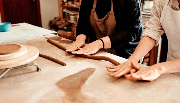 Teamwork is always the secret ingredient. two artisans working together in a pottery workshop - Foto, imagen