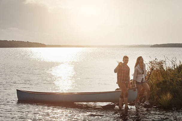 Algunas de las fechas más memorables suceden al aire libre. una joven pareja que va a dar un paseo en canoa por el lago - Foto, Imagen