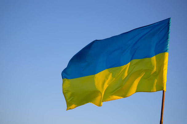 Detail of the national flag of Ukraine waving in the wind on a clear day. Democracy and politics.  - Foto, Bild