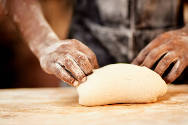 Зустрінемося на всіх твоїх колінах. чоловічий пекар зайнятий формуванням тіста на роботі
 - Фото, зображення