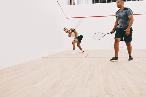 La agilidad es su mejor amigo en este juego. dos jóvenes jugando un juego de squash - Foto, Imagen