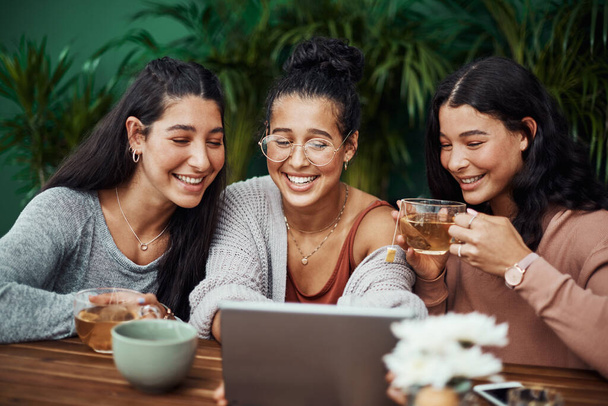 Pasa tiempo con tus chicas y mantén esa conexión. hermanas jóvenes usando una tableta digital juntas en un café - Foto, imagen
