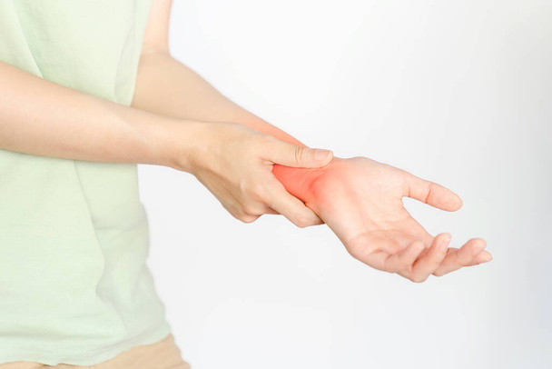 Une femme tenant son poignet en raison d'une blessure ou d'une polyarthrite rhumatoïde. - Photo, image