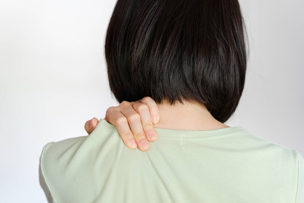 Woman showing pain in shoulder because of muscle inflammation. - Photo, Image