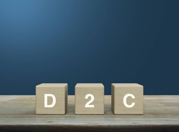 D2C acronym on wood block cubes on wooden table over light blue wall, Direct to Consumer concept - Foto, Imagem