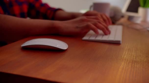Gehavend zicht op een man die aan een tafel zit en aan een computer werkt. Mannelijke handen typen op het toetsenbord. Hoge kwaliteit 4k beeldmateriaal - Video