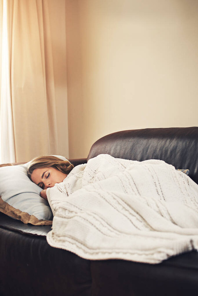 Il n'est jamais trop tôt pour faire une sieste. une jeune femme dormant paisiblement sur le canapé à la maison - Photo, image