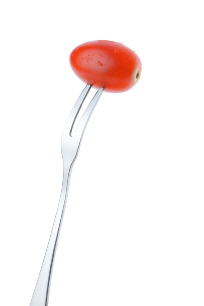 cherry plum tomato on fork isolated on white background - 写真・画像