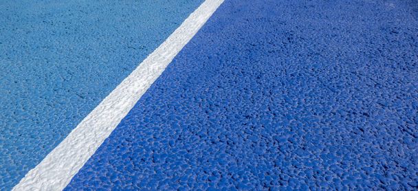 Sport field court background. Blue rubberized and granulated ground surface with white lines on ground. Top view, copy space - Photo, Image