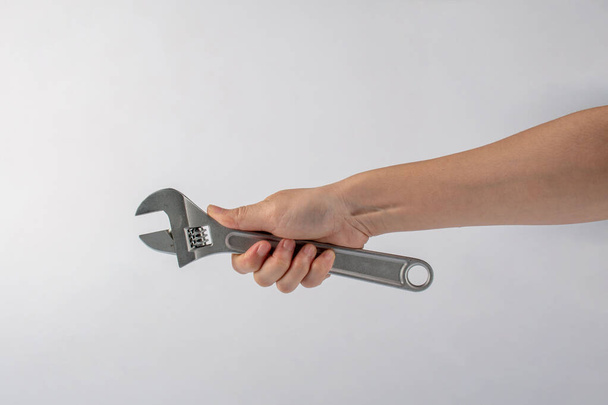 Hand and a wrench isolated on white background. - Фото, зображення