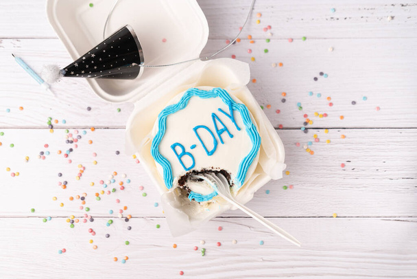 Flay lay with Half eaten Birthday mini cake on white table background with spoon. - Фото, зображення