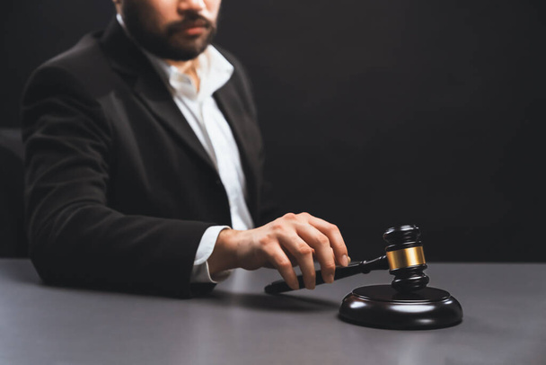 Фокус деревянный молоток молоток с зарытым адвокатом в черном костюме держа молоток на заднем плане на столе, символ правовой справедливости и целостности, сбалансированное и этическое решение в суде равновесия - Фото, изображение