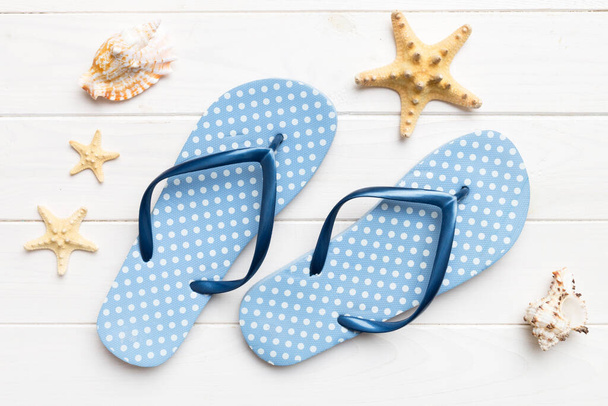 Flat lay composition with flip flops and seashell on colored background. Space for text top view. - Фото, зображення