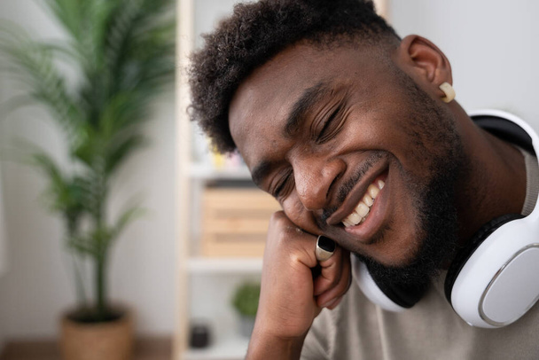 Detailní záběr mladého černocha s úsměvem se zavřenýma očima a přemýšlením. - Fotografie, Obrázek