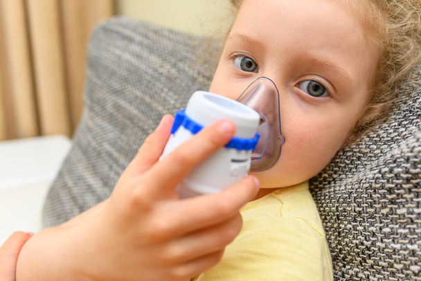 The child breathes through an inhaler. Treatment of colds and allergies. - Fotó, kép