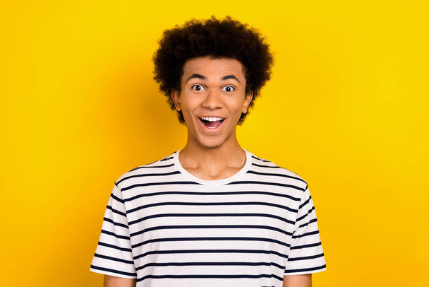 Photo of funky youngster guy overjoyed face open mouth good news wear striped white black t-shirt isolated yellow color background. - 写真・画像