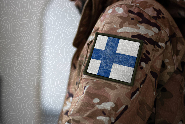 Φιλανδός. Στρατιώτης με σημαία Φινλανδίας, σημαία Φινλανδίας με στρατιωτική στολή. Ενδύματα παραλλαγής - Φωτογραφία, εικόνα