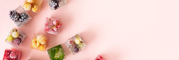 Заморожені кубики льоду з різними фруктами банер, ожина і малина, агрус і смородина, чорниця і м'ята, вид зверху
 - Фото, зображення