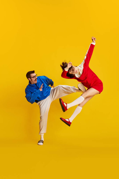 Family conflict. Portrait of couple, man and woman wearing retro style clothes arguing to each other over yellow studio background. Concept of family, relationship, love, human emotions, retro, ad - Foto, Bild