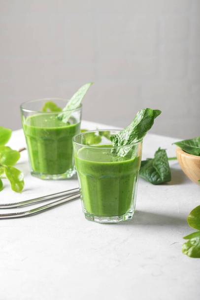 Gesunder grüner Smoothie mit Spinat, Banane und veganer Milch in zwei Gläsern und frischen Zutaten. Detox, Ernährung, gesundes, vegetarisches Ernährungskonzept mit Kopierraum - Foto, Bild