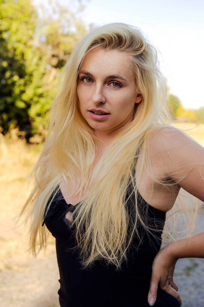 portrait of a beautiful blonde girl in a black dress - Foto, imagen