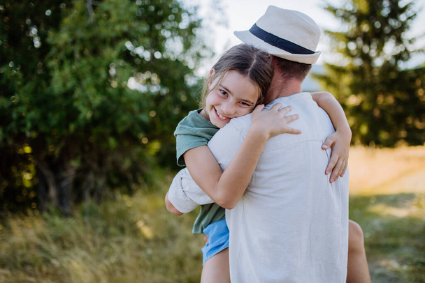 A father hugging his daughter in summer in nature. Fathers day concept. - Fotoğraf, Görsel