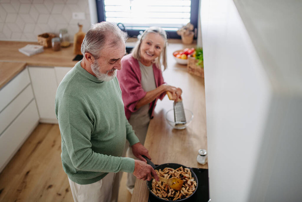 Senior couple cooking together in the kitchen. - 写真・画像