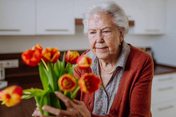 Portrait of senior woman with bouquet of flowers. - Fotografie, Obrázek