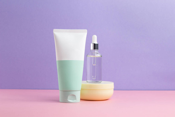 Skin care products, foam, serum, cleanser.  three products on a pink and lilac background.  Lots of free space - Foto, imagen