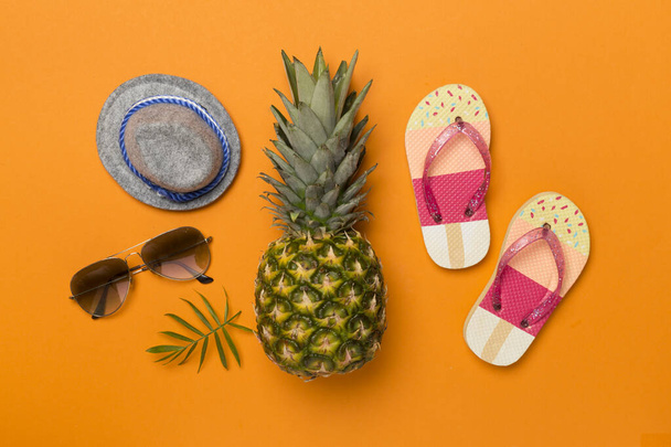 Creative pineapple hipster in sunglasses on color background, top view - Fotó, kép