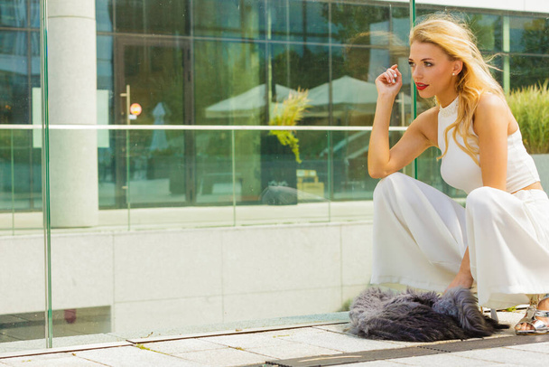 Elegant fashionable woman presenting trendy urban outfit. White crop top and trousers culottes. Outdoor photo session, unusual bizarre pose - Φωτογραφία, εικόνα