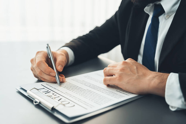 Businessman signs contract agreement paper or business legal form with trust and professionalism. Closeup of hand holding pen in corporate meeting for official business deal. Equilibrium - Photo, Image