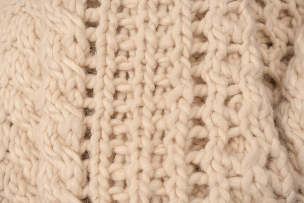 A fragment of beige knitted fabric, knitted from white sheep wool. Knitted background.  - Fotoğraf, Görsel
