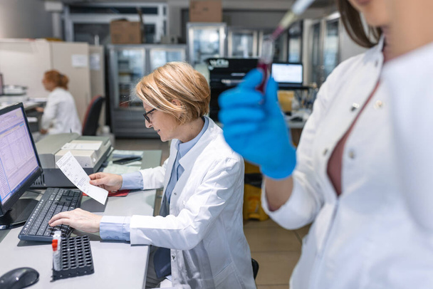 Közelkép a kéz a kesztyűben Micro Pipette használata közben dolgozik Test Tubes. Emberek az innovatív gyógyszerészeti laboratóriumban modern orvosi berendezésekkel a genetikai kutatáshoz. - Fotó, kép