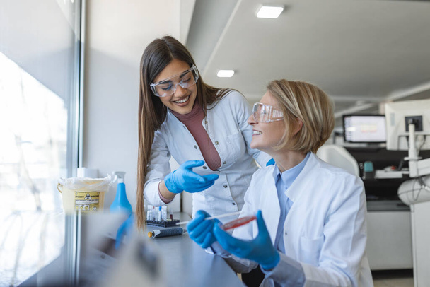 Modern Medical Research Laboratory: Two Scientists Working Together Analysing Chemicals in Laboratory, Discussing Problem. Advanced Scientific Lab for Medicine, Biotechnology, Molecular Biology - Foto, immagini