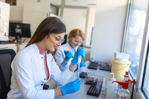 Modern Tıbbi Araştırma Laboratuvarı: Mikro Pipette ile çalışan Kadın Bilimadamı, Biyokimya Örnekleri Analizi. Gelişmiş Tıp, Mikrobiyoloji Geliştirme Laboratuvarı. - Fotoğraf, Görsel