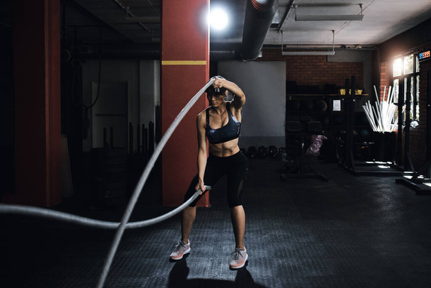 Prove them wrong one last time. a young woman doing heavy rope training at the gym - Foto, Imagem